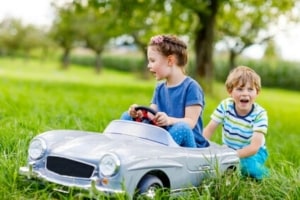 Graues Elektroauto mit zwei Kindern